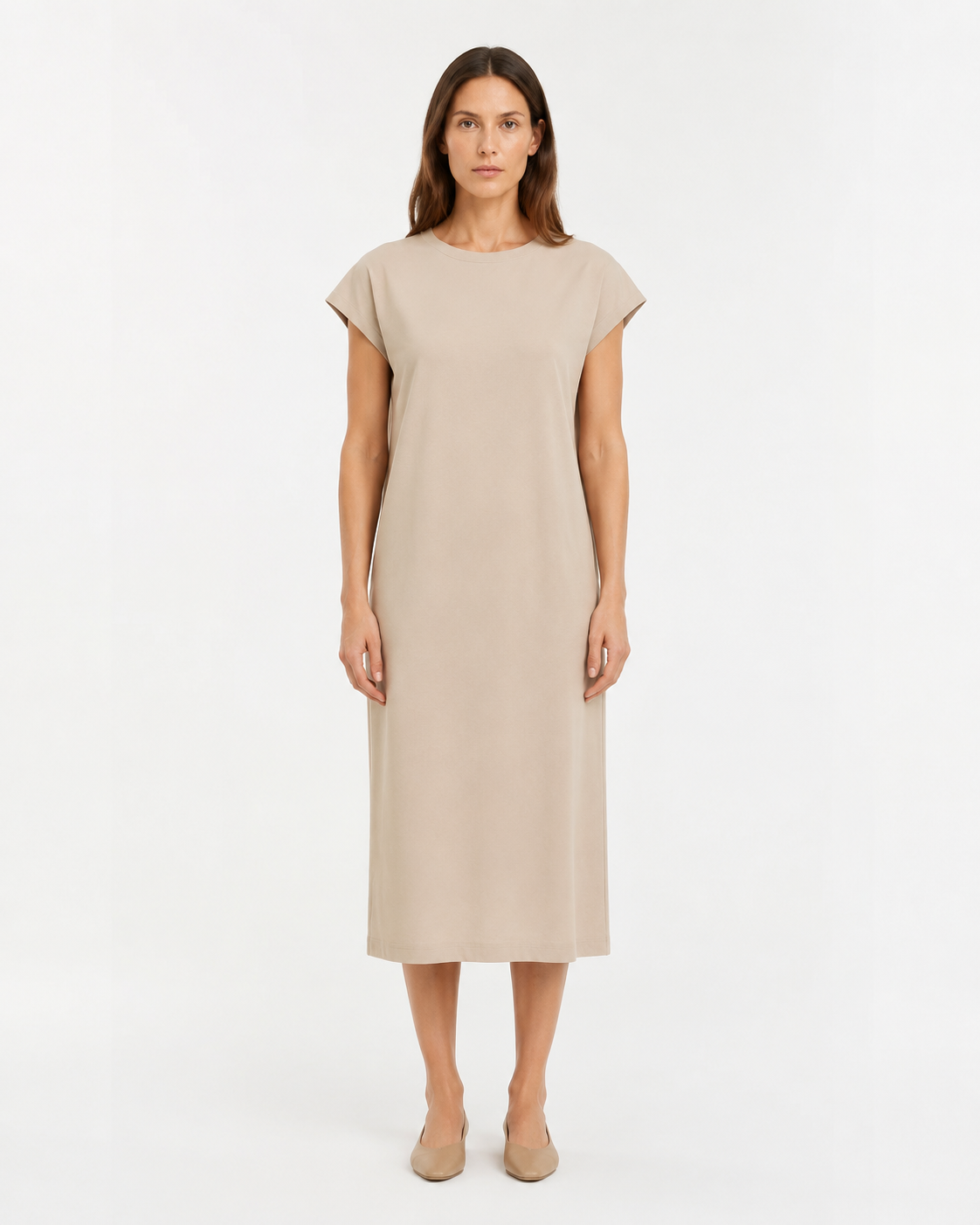 Adult fashion model in a plain beige dress against a white studio background